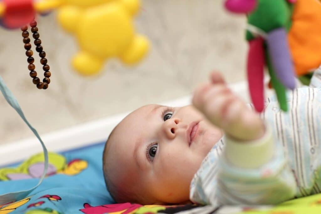 Bébé très concentré sur son tapis d'éveil