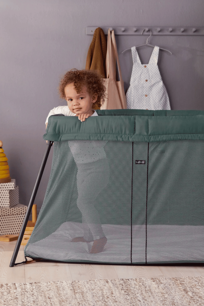 Tout petit debout dans un lit parapluie