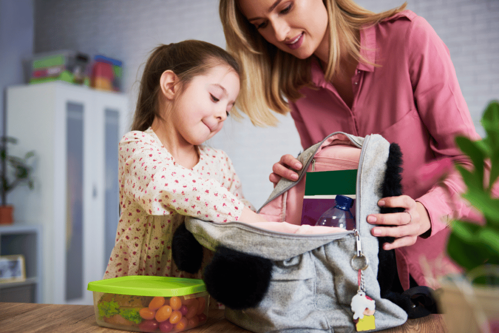 Maman en train d'aider sa fille à faire son sac d'école